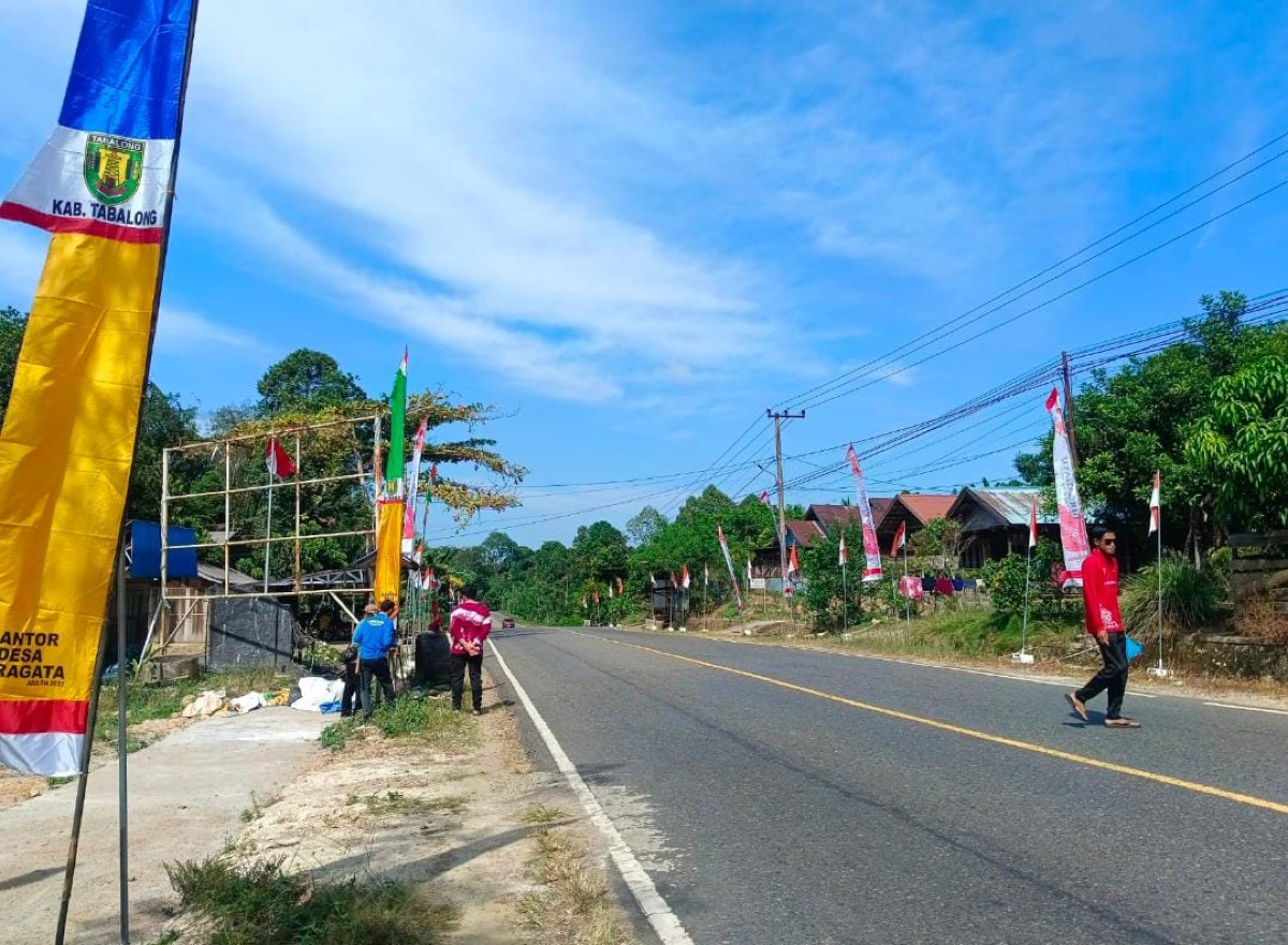 Pemerintahan Desa Garagata gotong royong pemasangan bendera merah putih dan umbul-umbul untuk menyambut bulan Agustus
